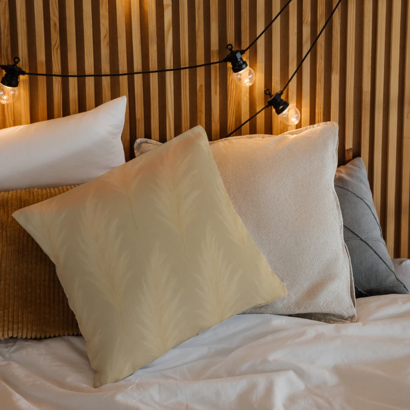 Natural pampas throw pillow on boho bedroom with layered neutral textiles