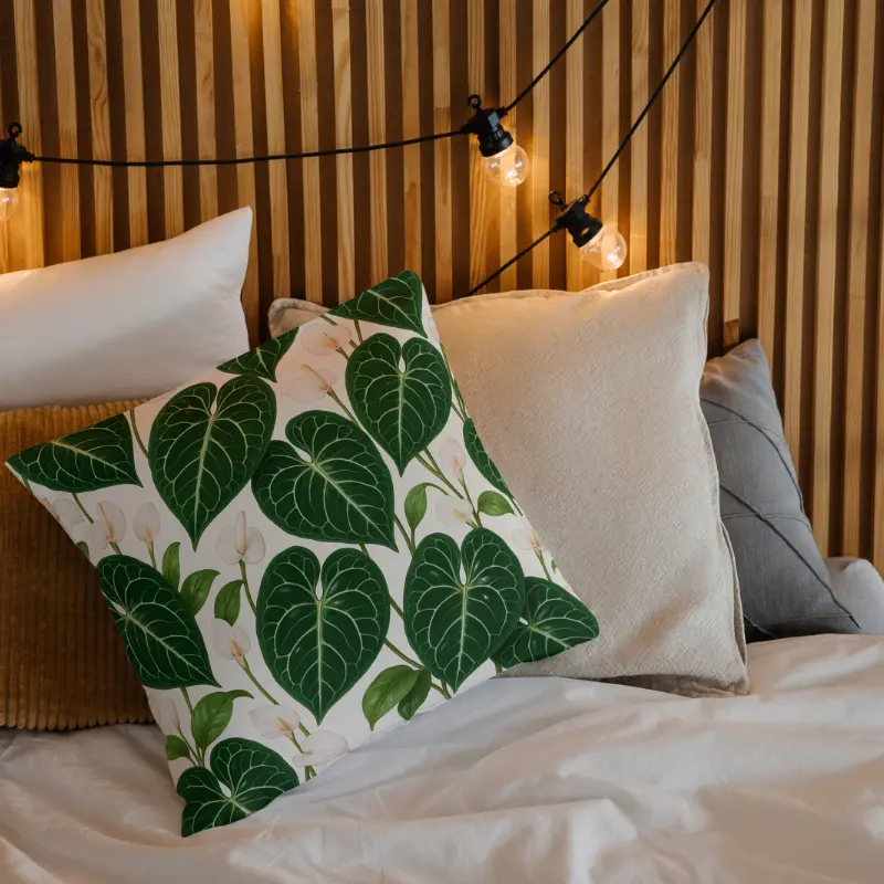 Anthurium crystallinum floral throw pillow layered on a minimalist bed setting