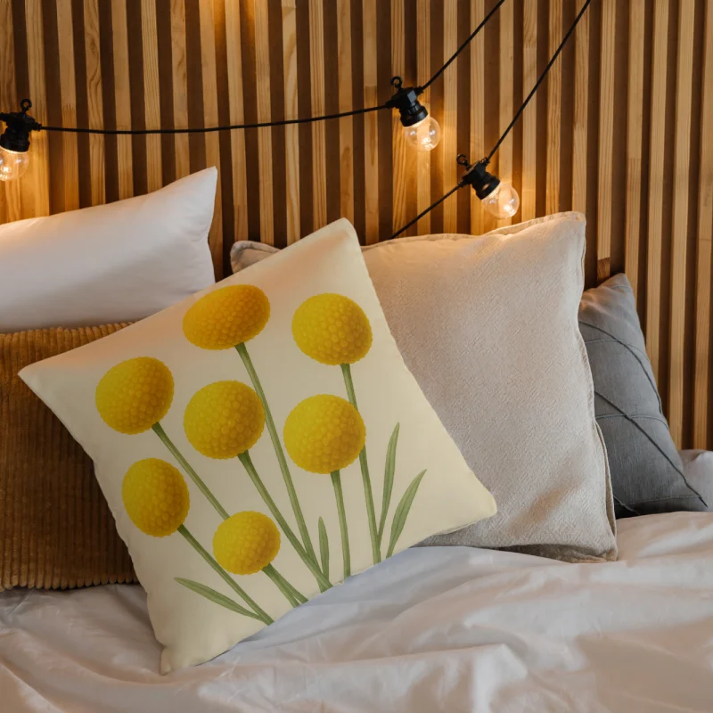Billy Buttons watercolor floral throw pillow layered on a cozy bed