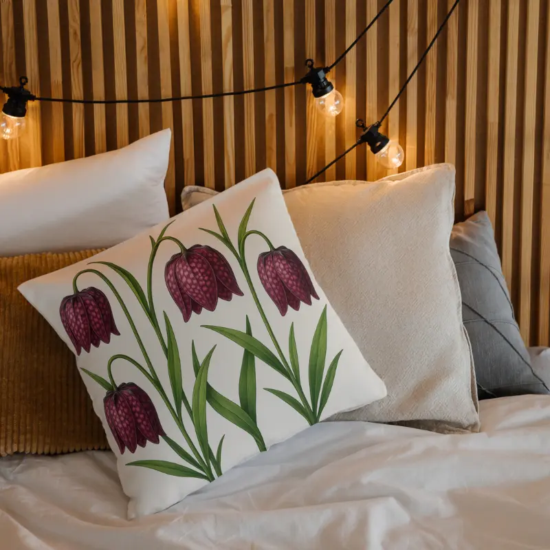 Checkered Lily botanical floral throw pillow styled on a cozy bed for elegant home decor