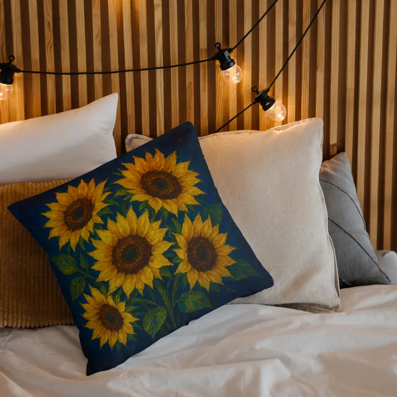 Sunflower oil-impasto throw pillow on light bedding with navy backdrop tones and green stems and leaves