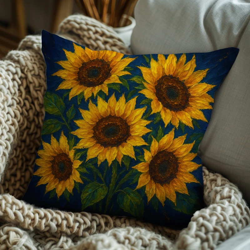 Sunflower impasto pillow on charcoal sofa; glowing yellow petals, textured brown centers, emerald and moss leaves